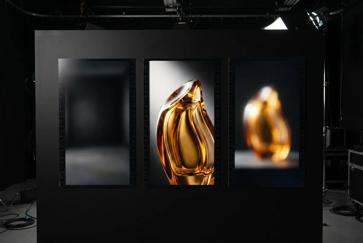 Beauty product showcase: amber bottles displayed in a studio lit by warm amber.